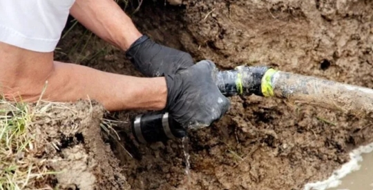 A person is fixing an underground pipe