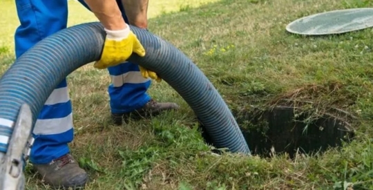 A plumber is cleaning a clogged drain