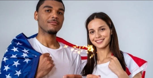 A man and a woman carrying the American flag
