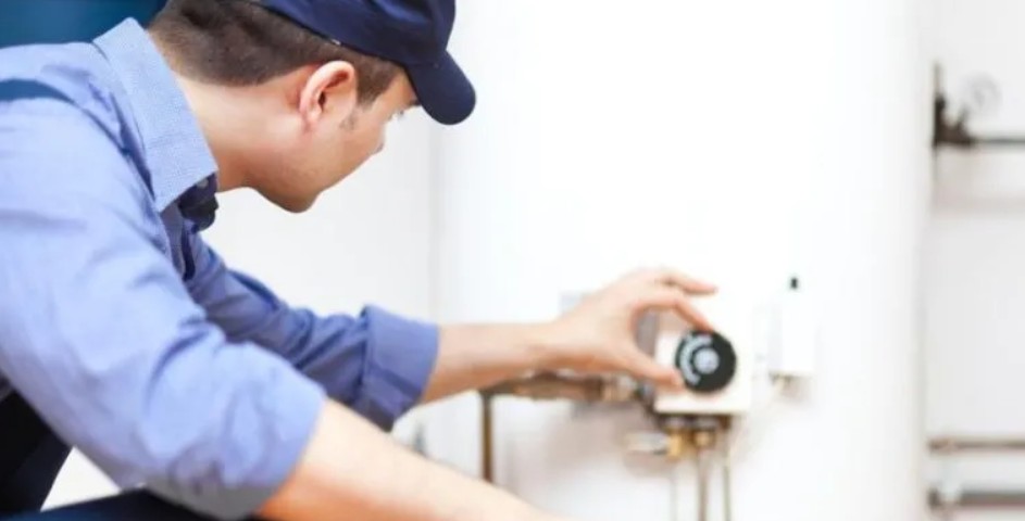A plumber adjusting the water heater