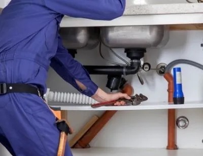 A plumber is fixing a sink