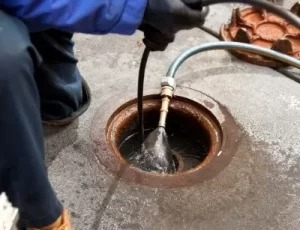 A plumber is snaking a drain