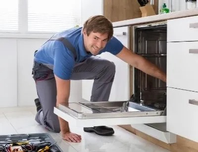 A plumber is smiling at the camera, ready to fix the sink