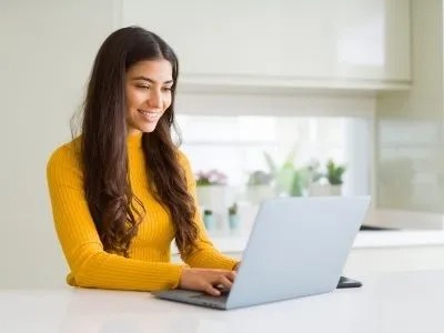 A woman is using her laptop