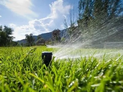 A grass is spraying by sprinkler