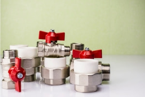 Metal valves and joints with red handles.